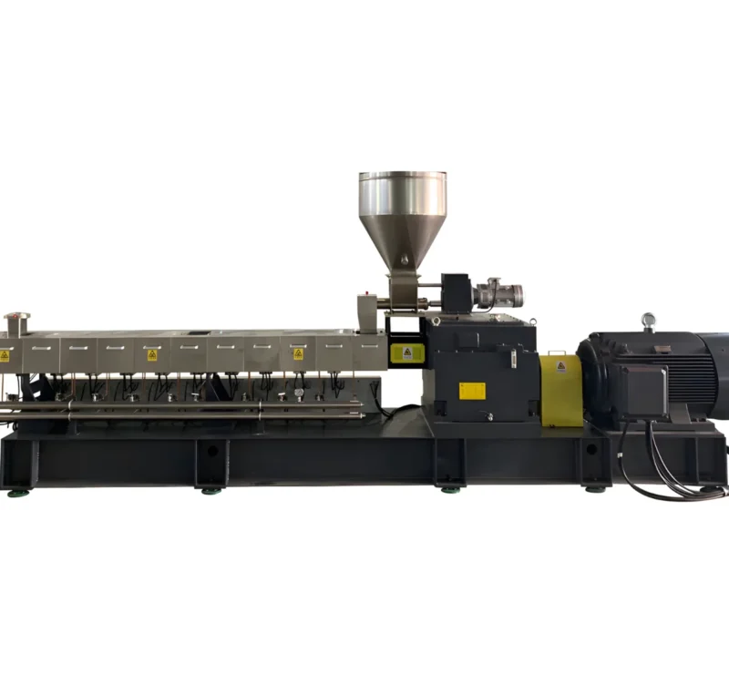 The image shows an industrial machine, which appears to be a plastic granulator or extrusion machine. This equipment is commonly used in the plastic processing industry for recycling or creating plastic pellets. It includes components like a hopper for feeding plastic material, an extrusion chamber, and a motor, which drives the extrusion process. The processed plastic is typically melted, extruded, and formed into pellets or other shapes.