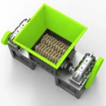 a shredder, specifically designed for industrial use. This type of shredder likely features robust, rotating cutting mechanisms, which are ideal for breaking down large volumes of materials such as plastics, rubber, or waste products into smaller, manageable sizes. The bright green feeding area emphasizes the machine’s input section, where materials are introduced into the shredding system.