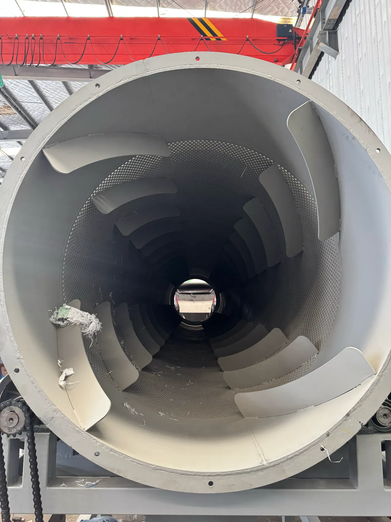 Tamis à trommel industriel séparant des matériaux à l'intérieur d'une installation de recyclage.