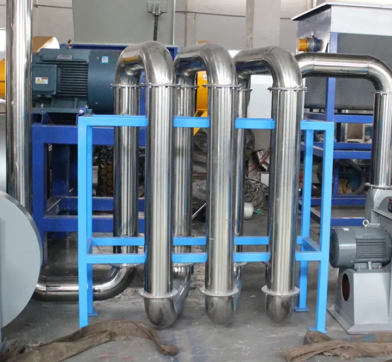 uma máquina de secagem térmica, que faz parte de um sistema industrial projetado para secar materiais usando calor. A configuração inclui uma série de tubos e cilindros de metal, provavelmente para o transporte de materiais e ar quente. Vários motores e componentes mecânicos visíveis na imagem sugerem que este sistema opera com uma combinação de calor e movimento mecânico para obter uma secagem eficiente. O uso de aço inoxidável e a estrutura robusta indicam que ele foi construído para durabilidade e alto desempenho em ambientes industriais.