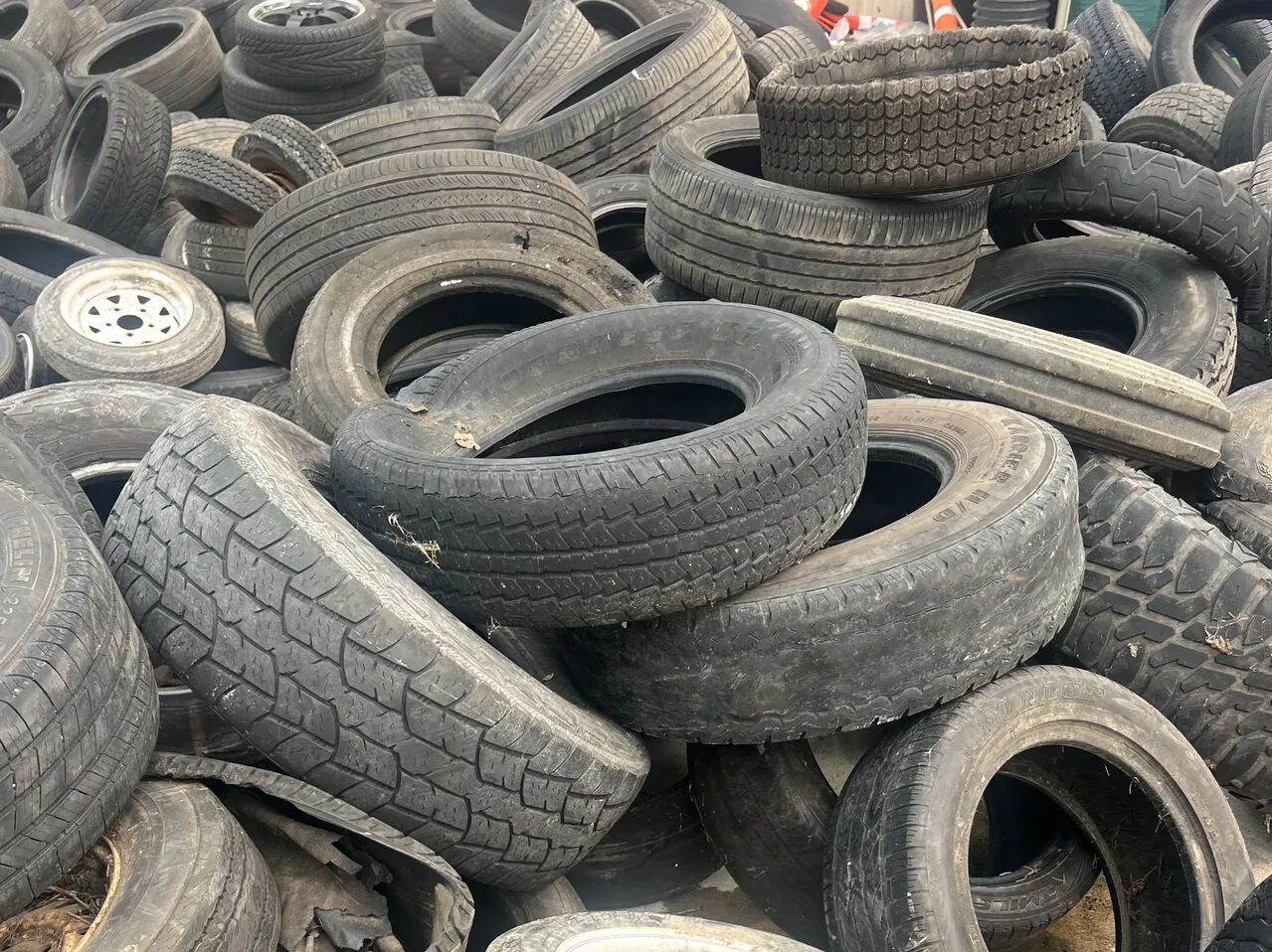 Waste car and truck tires scrap awaiting shredding and recycling